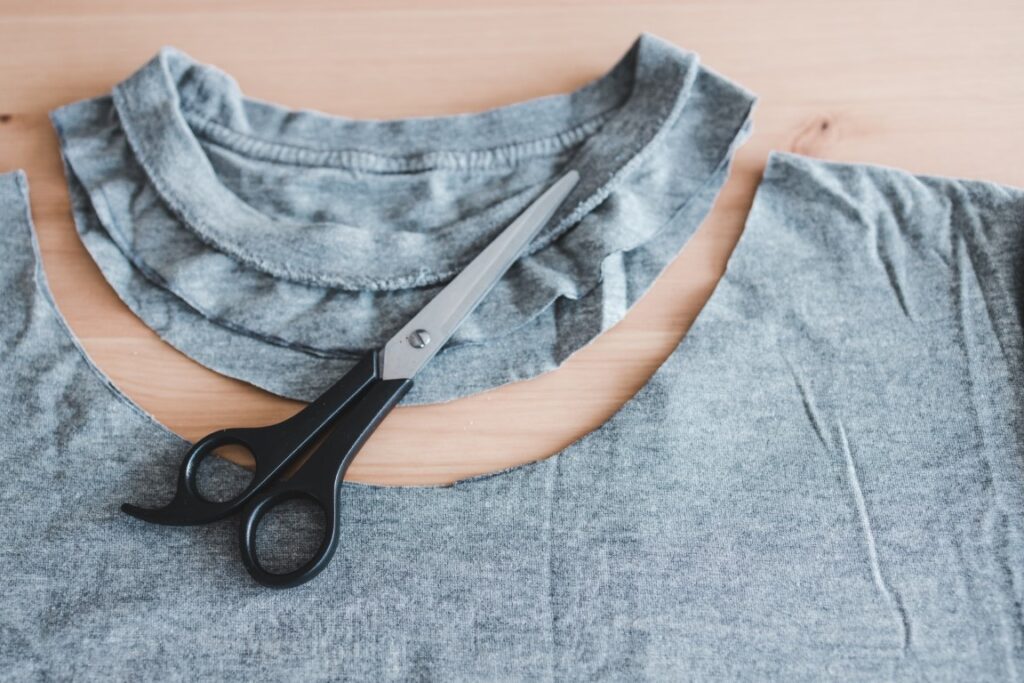 upcycling old clothes concept, t-shirt with scissors to cut a ne