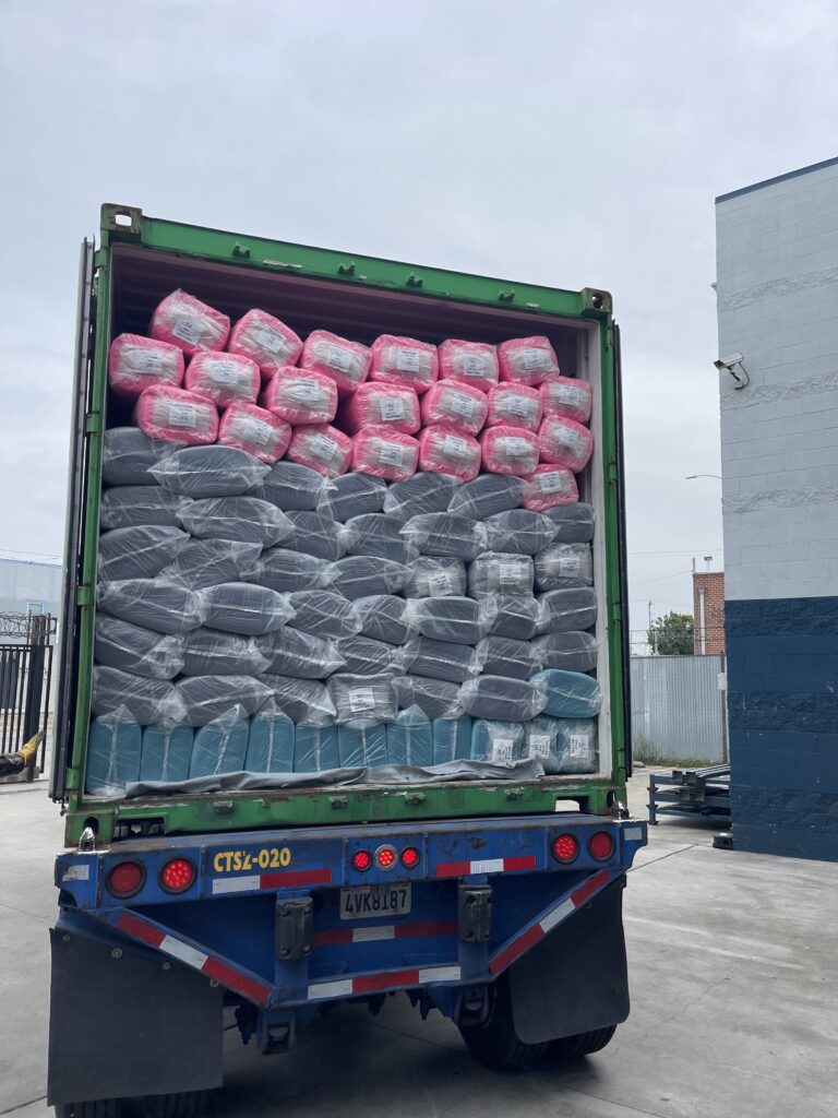 A row of colorful fabric rolls stacked neatly on the container